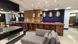 Sala de estar com sofá grande e piso de madeira aparente.