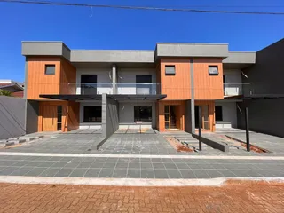 Fachada moderna de uma casa em Lajeado, Brasil, com revestimento de madeira e detalhes em cinza.
