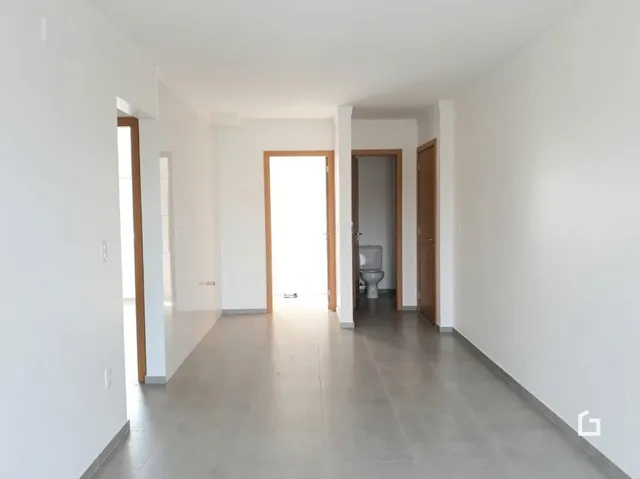 Corredor interno de uma residência branca.