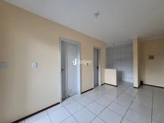 Hall de entrada com piso de cerâmica e portas brancas.