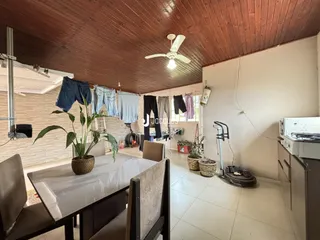 Interior de uma sala com teto de madeira e área de jantar.
