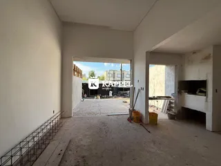 Interior de um espaço com vista para uma área externa em construção.