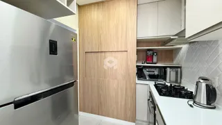 Uma cozinha moderna com armários de madeira e bancadas brancas.