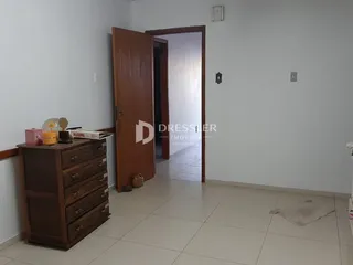 Vista de um corredor interno com um armário de madeira e uma porta aberta.