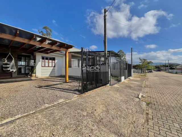 Vista externa de uma residência com cerca de metal e estrutura de madeira em Lajeado.