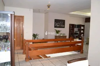 Interior de um quarto com estrutura de madeira e piso de cerâmica.