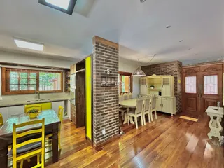 Uma sala de jantar com piso de madeira e parede de tijolos aparentes.