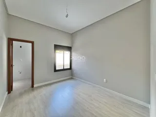 Ambiente interno de uma sala com piso de madeira clara.