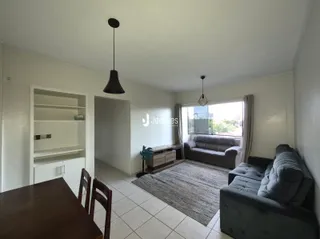 Sala de estar com sofá e janela em um imóvel no Brasil.