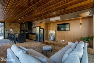 Sala de estar com piso de madeira e decoração moderna em Lajeado.