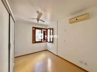 Sala de estar com piso de madeira e janela.