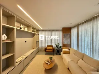 Sala de estar com sofá e estantes em um ambiente claro.