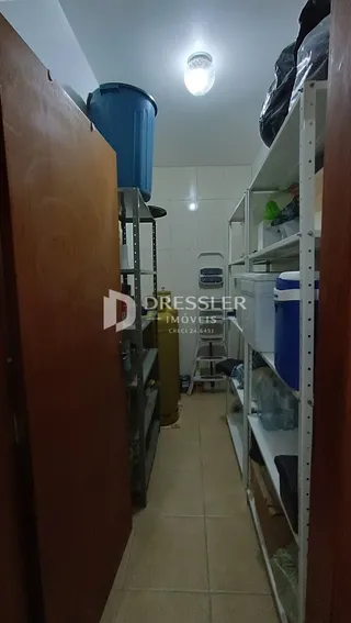 Foto de um corredor interno com paredes brancas e piso de cerâmica.