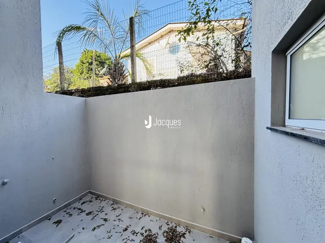Parede externa de uma propriedade em Lajeado, Brasil, com piso de terra e vegetação.