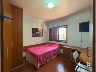Quarto com cama e armário de madeira em um imóvel no Brasil.