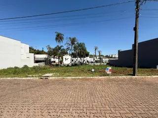 Vista externa de um complexo residencial com edifícios brancos ao fundo.