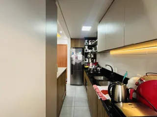 Vista interna de uma cozinha com armários e eletrodomésticos.