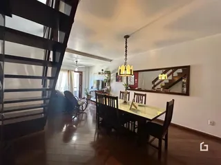 Ambiente interno com piso de madeira e sala de jantar.