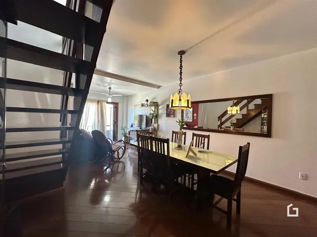 Ambiente interno com piso de madeira e sala de jantar.
