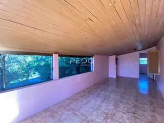Corredor interno com piso de cerâmica e teto de madeira