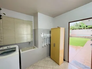 Ambiente interno mostrando uma área com máquina de lavar e banheira.