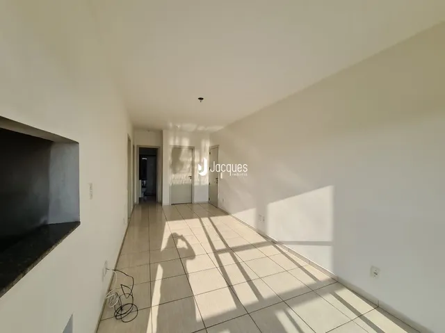 Corredor interno com piso de cerâmica claro.