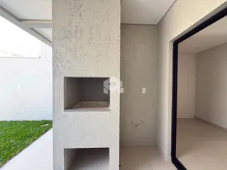 Parede de concreto com nichos e abertura para outro cômodo em uma residência.