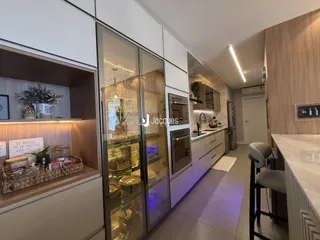 Cozinha moderna com armários brancos e eletrodomésticos de aço inoxidável.
