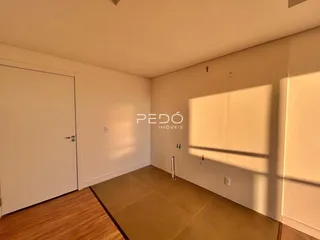 Interior de uma sala com piso de cerâmica e paredes brancas.