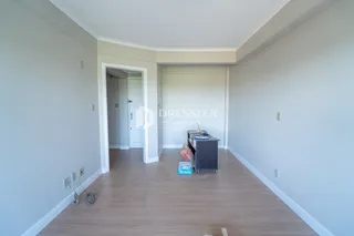 Corredor interno de uma residência com piso de madeira clara.