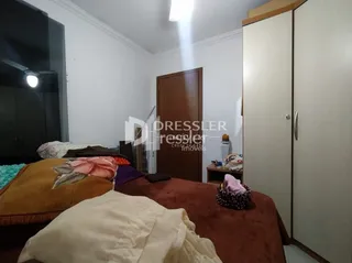 Quarto com cama e parede de madeira no interior da propriedade.