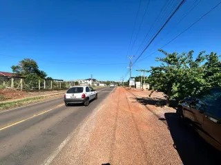 Foto de uma estrada rural com um veículo.