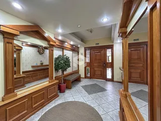 Hall de entrada com revestimento de madeira e espelhos.