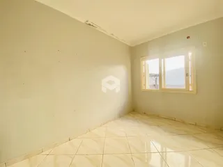 Vista interna de um cômodo com paredes claras e piso de cerâmica.