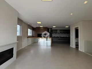 Ambiente amplo de sala de estar e cozinha em um imóvel no Brasil.