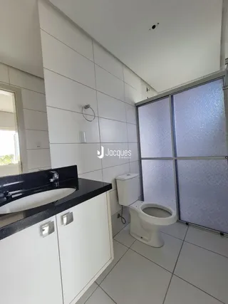 Foto do interior de um banheiro com revestimento branco.