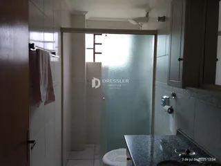 Interior de um banheiro com revestimento cerâmico e porta de madeira.