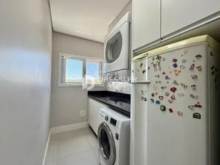Interior de uma cozinha com armários brancos e piso de cerâmica.