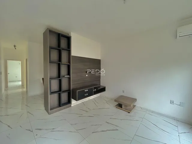 Sala de estar com piso de porcelanato claro e parede de destaque.