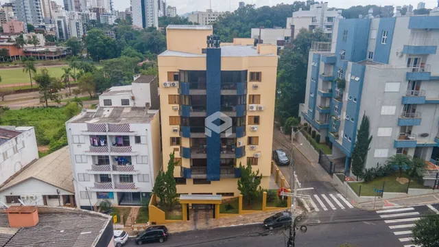 Fachada de um prédio residencial em Lajeado, Brasil, com cores amarelo e azul.