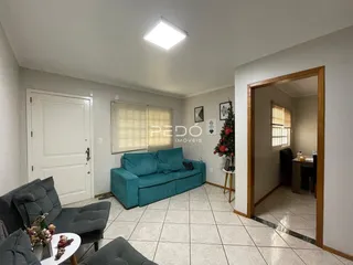 Sala de estar com sofá azul e piso de cerâmica clara.