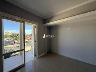 Interior de uma sala com grandes portas de vidro que dão vista para a paisagem.