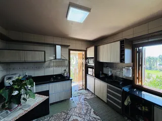 Vista da cozinha com armários e piso de cerâmica em Lajeado.