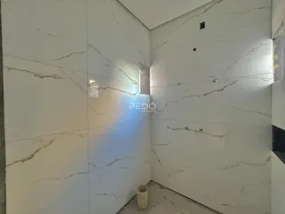 Parede interna com revestimento de mármore claro em um ambiente.