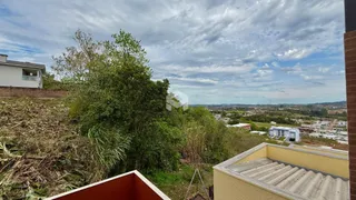 Vista externa da propriedade com vegetação densa e paisagem ao fundo.