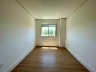 Hall de entrada com piso de madeira e paredes brancas.