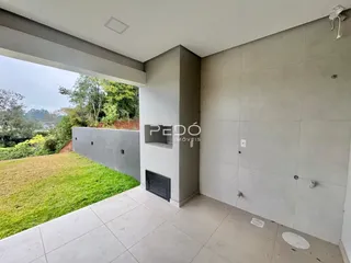 Vista de uma área externa com piso de cerâmica e parede de concreto em Lajeado.