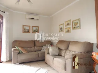 Sala de estar com sofá e quadros na parede.