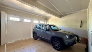 Sala de estar com garagem e carro estacionado na área interna.
