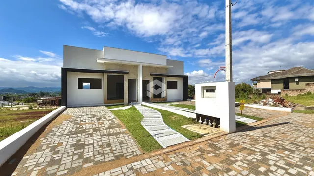 Fachada de uma casa moderna com jardim e calçada em Lajeado, Brasil.